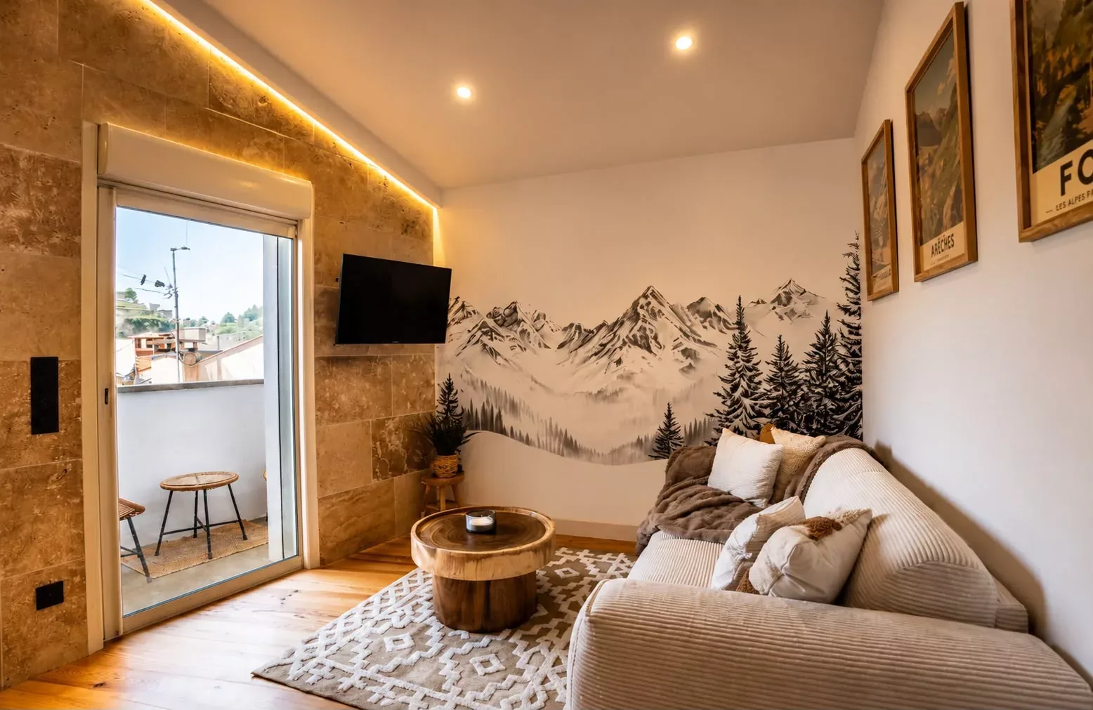 Salon avec fresque montagne, éclairage indirect et mobilier chaleureux